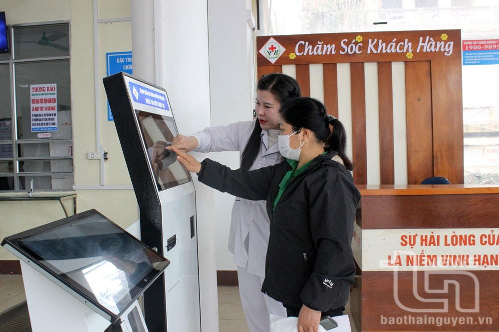 Người dân sử dụng thẻ căn cước công dân để lấy số thứ tự khám tại cây Kios.